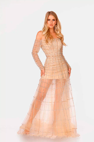 Woman wearing a champagne colored evening gown with sheer overlay on a white background