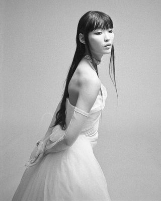 Vivienne Westwood luxury wedding dress with artisanal draping and detachable tulle train, offering a personalized, made-to-order experience.