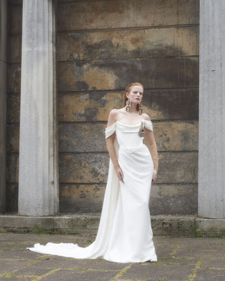 Vivienne Westwood iconic bridal design with sculptural bodice draping, detachable cape, and exquisite eco-conscious materials.