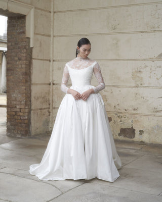 Vivienne Westwood luxury wedding dress featuring a structured corset bodice, voluminous pleated skirt, and dramatic side slit.