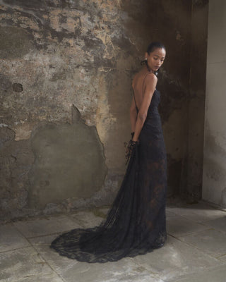 Diagonal-back view of the Lace Minerva gown in black, capturing the elegant train and layered lace design.