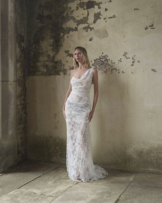 Full body front view of the Lace Minerva gown in white, highlighting the non-corseted backless design and sensual silhouette.
