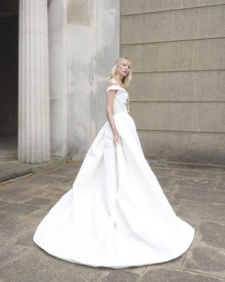 Side view of the Nova Bagatelle gown showcasing the full pleated skirt and almond-shaped train.