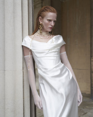 Vivienne Westwood couture gown inspired by 18th-century elegance, crafted in pearl white silk for timeless bridal sophistication.