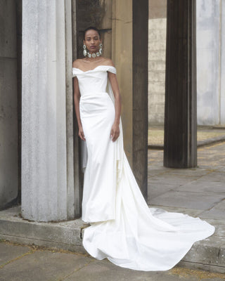 Full-body front view of a model wearing the Nova Cora gown with minimal drapery along the hips.