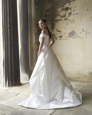 The Diva Train by Vivienne Westwood, showcasing its baroque structure and intricate pleat work, elegantly wraps around the waist with a hidden bow for added drama.
