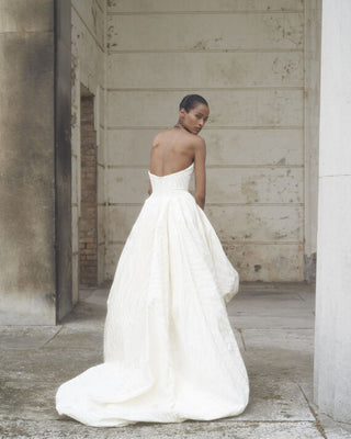 Back view of the Victoria gown, featuring the beautifully constructed corset and the luxurious layered skirt that cascades elegantly behind.