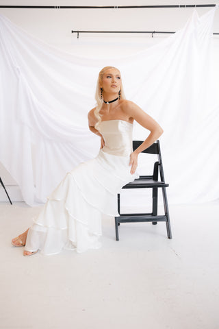 Chic sleeveless bridal dress with a structured bodice and voluminous tiered ruffles, blending contemporary elegance with classic charm.