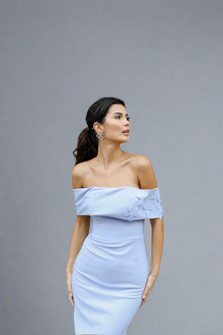 Model wearing the Lucia Bardot gown by Nadia’s, showcasing the chic floral details on the neckline and fitted crepe bodice.