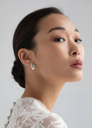 Luxury drop earrings showcasing intricate crystal detailing and a radiant pearl, crafted for high-fashion elegance.