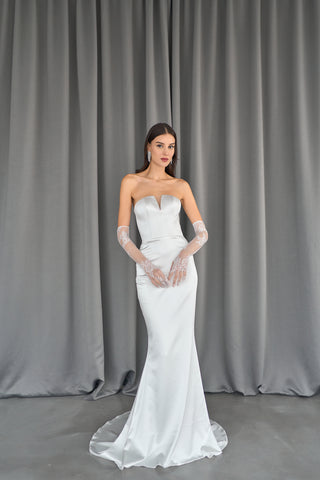 Sleek strapless bridal gown with a figure-hugging sheath silhouette and structured bodice