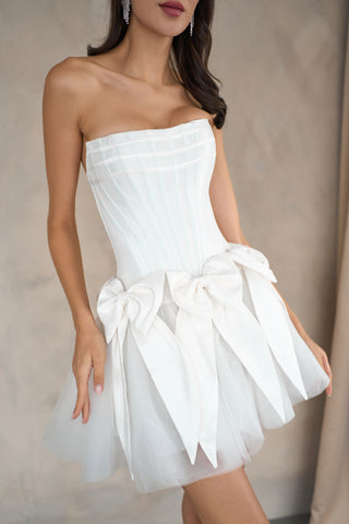 Playful yet luxurious mini dress featuring a sleek satin design and whimsical side bows