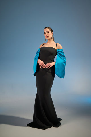 Graceful evening dress featuring a sleek column silhouette, structured neckline, and dramatic long off-shoulder sleeves.