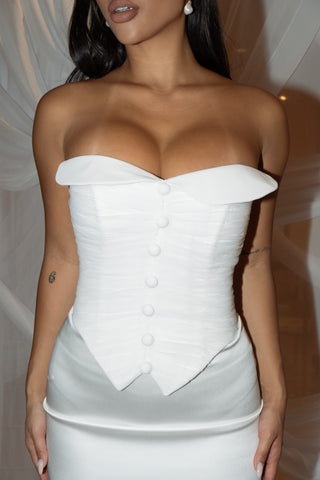 Modern bridal gown featuring a structured corset bodice, sleek column silhouette, and refined button details