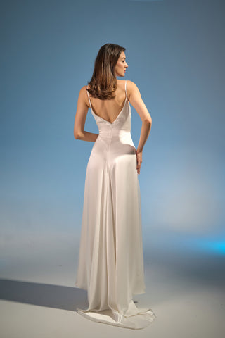 Modern bridal gown featuring spaghetti straps, a bias-cut silhouette, and a flowing, floor-length design