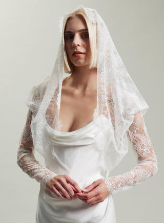 A luxurious display of Vivienne Westwood's signature design elements, featuring a delicate lace fichu blouse, perfect for modern brides.