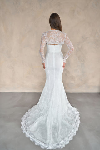 Fitted lace bridal gown in a dramatic mermaid silhouette with sleeveless elegance and a sophisticated floor-length train.
