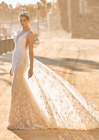 Fitted lace gown with embroidered straps and mermaid silhouette.