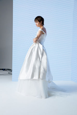 Side profile of Nebula gown highlighting asymmetrical skirt structure and draped bodice