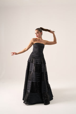 Refined maxi gown with a strapless structured bodice and tiered detailing, creating depth and texture for a glamorous evening look.