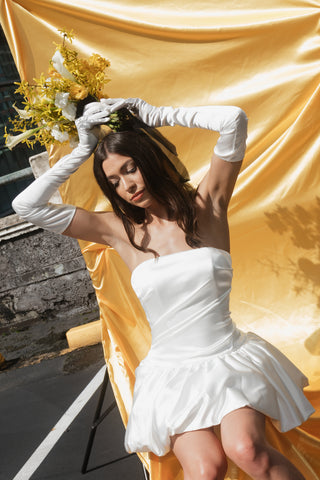 Contemporary strapless cocktail dress with cinched waist and exaggerated peplum finish for statement appeal