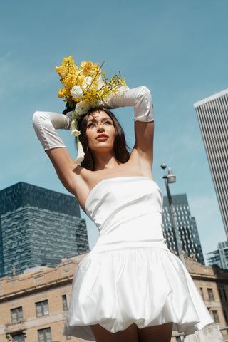 Strapless satin mini dress with structured bodice and voluminous peplum hem for a refined evening silhouette