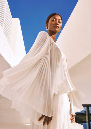 Side profile of model wearing off-white Seema Top with dramatic batwing sleeves.