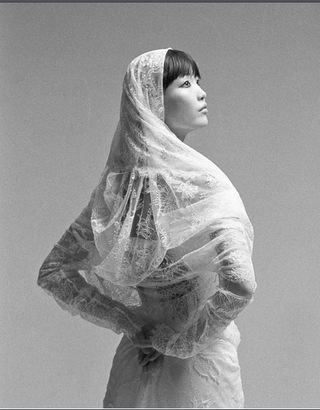 A striking side profile of a model showcasing the Vivienne Westwood lace fichu blouse, exuding timeless luxury and elegance.