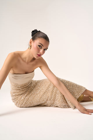 Model seated on the floor in the Cristos strapless beaded gown, showcasing the luxurious beading and column design.