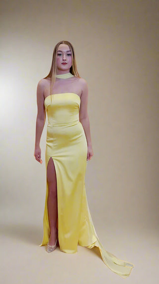 Strapless column gown with sleek silhouette and front slit, crafted for refined evening elegance.