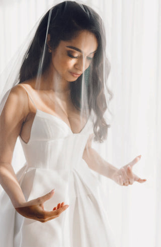 Bride in Maddison gown by Alex Perry, showing thin straps and fitted bodice.