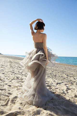 Romantic strapless ball gown with cascading organza layers and a voluminous skirt, perfect for an elegant evening look.