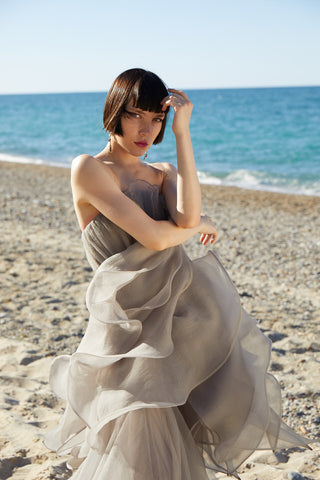 Ethereal floor-length gown featuring a strapless bodice and flowing, airy fabric for a graceful, fairytale-inspired silhouette.