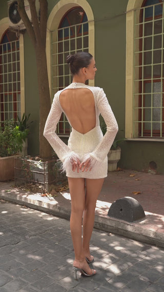 Modern bridal mini dress featuring a structured mock neckline, tulle-lined bodice, and luxurious feather-trimmed sleeves.