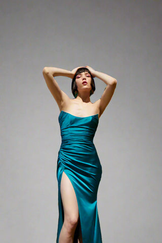 Elegant strapless evening gown with ruched bodice, rounded corset design, and side slit for a flowing, graceful silhouette