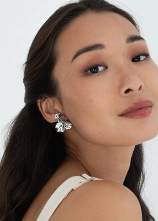 Close-up of a woman wearing silver earrings with a white background