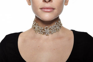 Close-up of a person wearing an ornate necklace on a white background