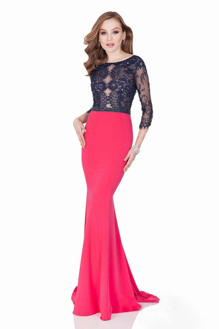 Woman wearing a pink evening gown with navy lace top on a white background