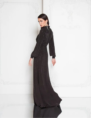 Woman wearing a black beaded evening gown against a white background