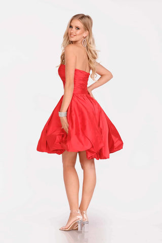 Woman wearing a red strapless dress on a white background