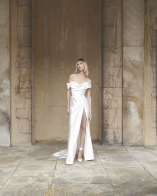 Front view of the Mabel gown, with the model posing gracefully to showcase the luxurious drape and silhouette.