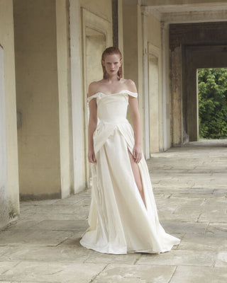 Full front view of the Tabitha gown in white, showcasing its layered draping and bias-cut skirt.