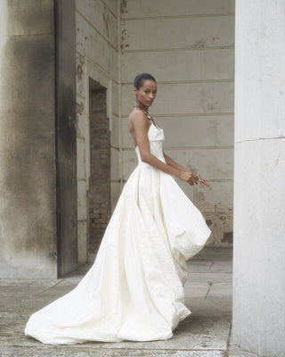 Side view of the Victoria gown in the lookbook, highlighting the gown’s unique asymmetrical design and the graceful movement of the fabric.