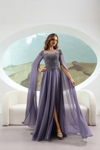 Woman wearing a long, light purple evening gown with a high slit in a modern indoor setting.