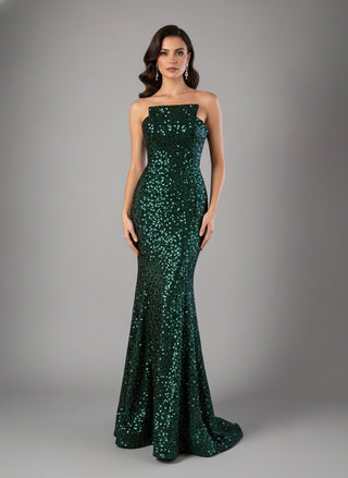 Woman wearing a green sequin dress against a gray background