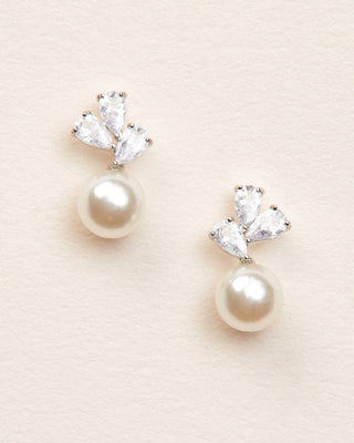 Pearl and crystal earrings on a beige background
