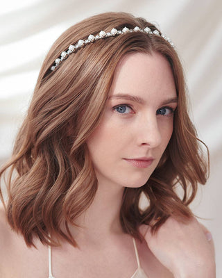 Woman wearing a decorative headband with pearls against a soft background