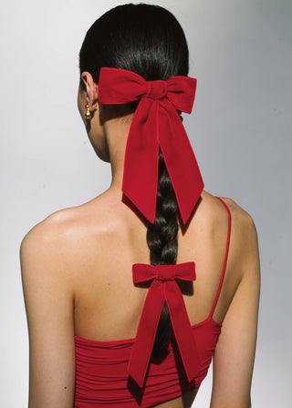 Model wearing Velvet Bow Barrette in Rouge – styled on a braid for a chic look