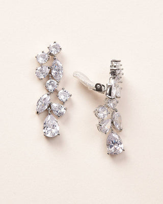 Pair of diamond earrings on a light beige background