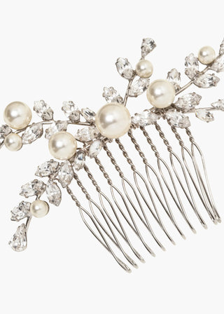 Handcrafted bridal comb with asymmetric crystal tendrils and luminous pearls, designed for an ethereal and elegant wedding look.